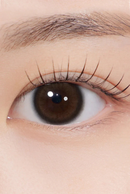 Close-up of an eye wearing glow brown colored contact lens, enhancing natural iris color